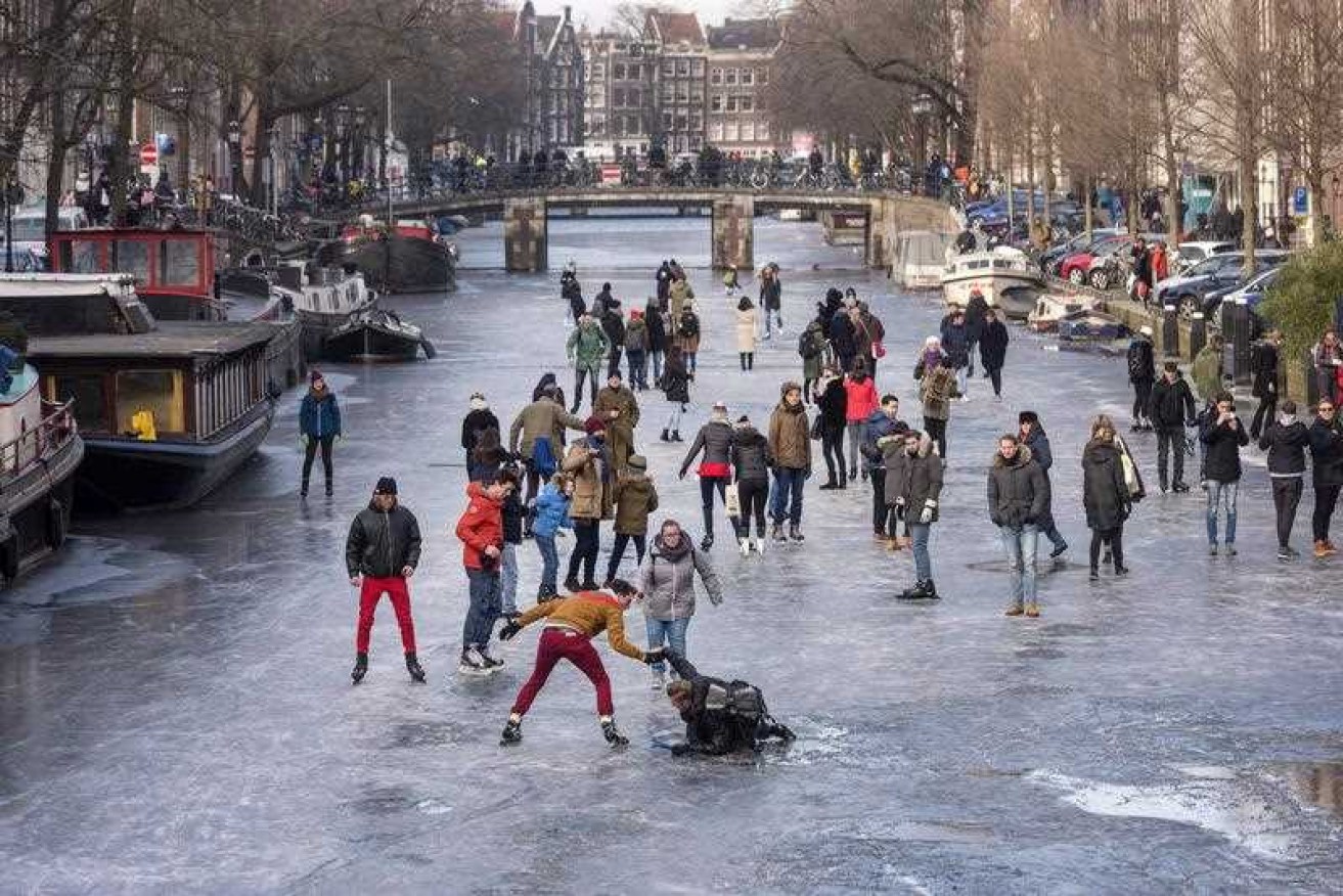 Children and adults in the Netherlands have been using ice skates and modified skateboards to glide over frozen canals.