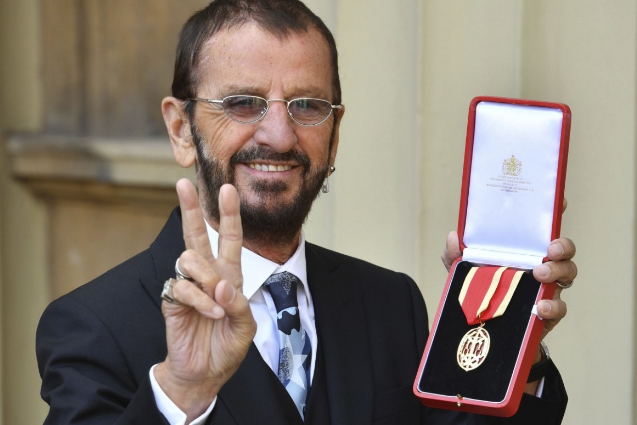 Ringo Starr poses with his new honour and his signature peace sign salute.