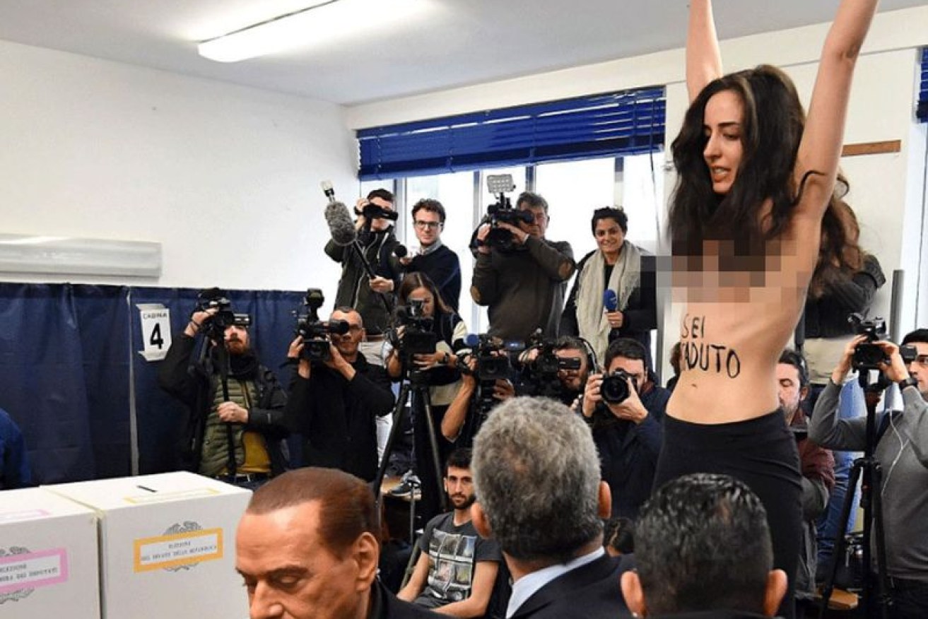 The words 'Berlusconi, you've expired' were emblazoned on the protester's chest.