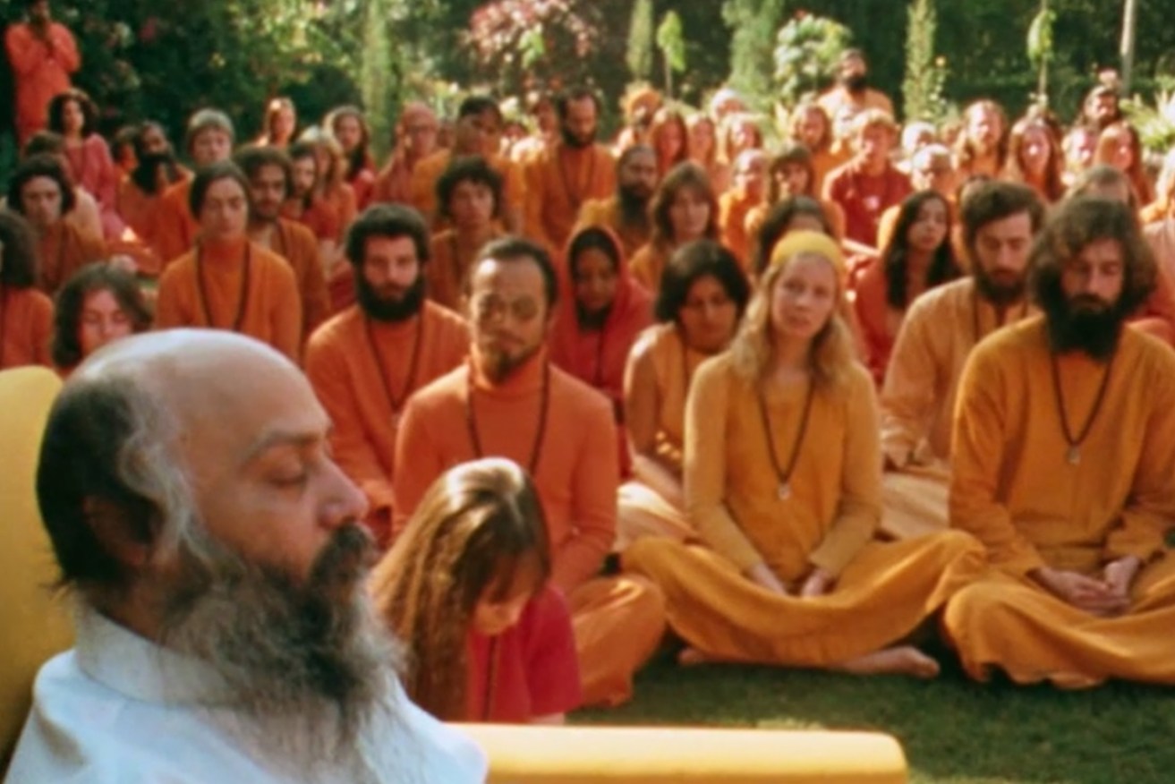 Bhagwan Shree Rajneesh (left) and his orange-clad followers.