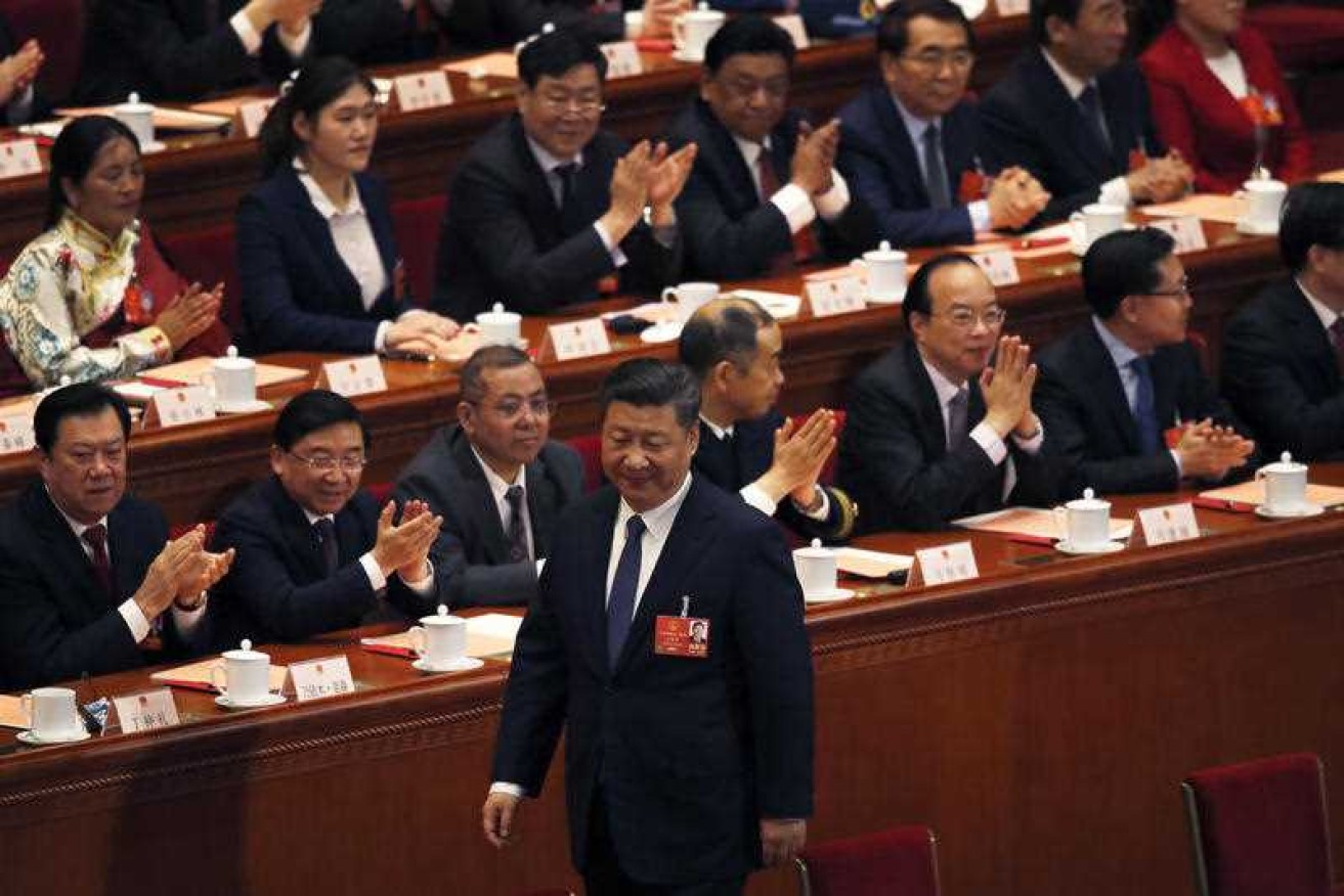 Delegates applaud as Xi Jinping walks to his seat after casting his vote to abolish term limits on the presidency.
