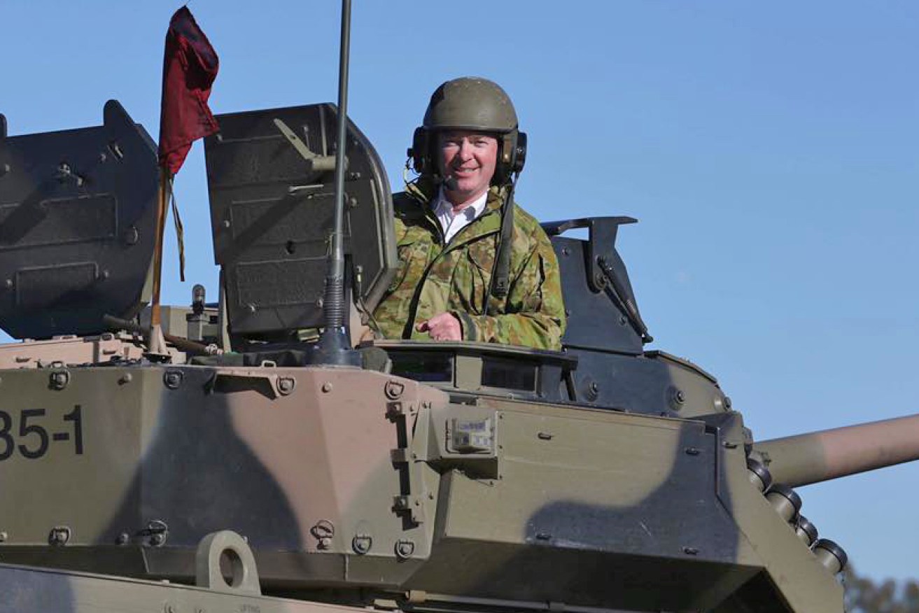 Christopher Pyne in the turret of a military vehicle during a live firing at Puckapunyal army base in 2017.