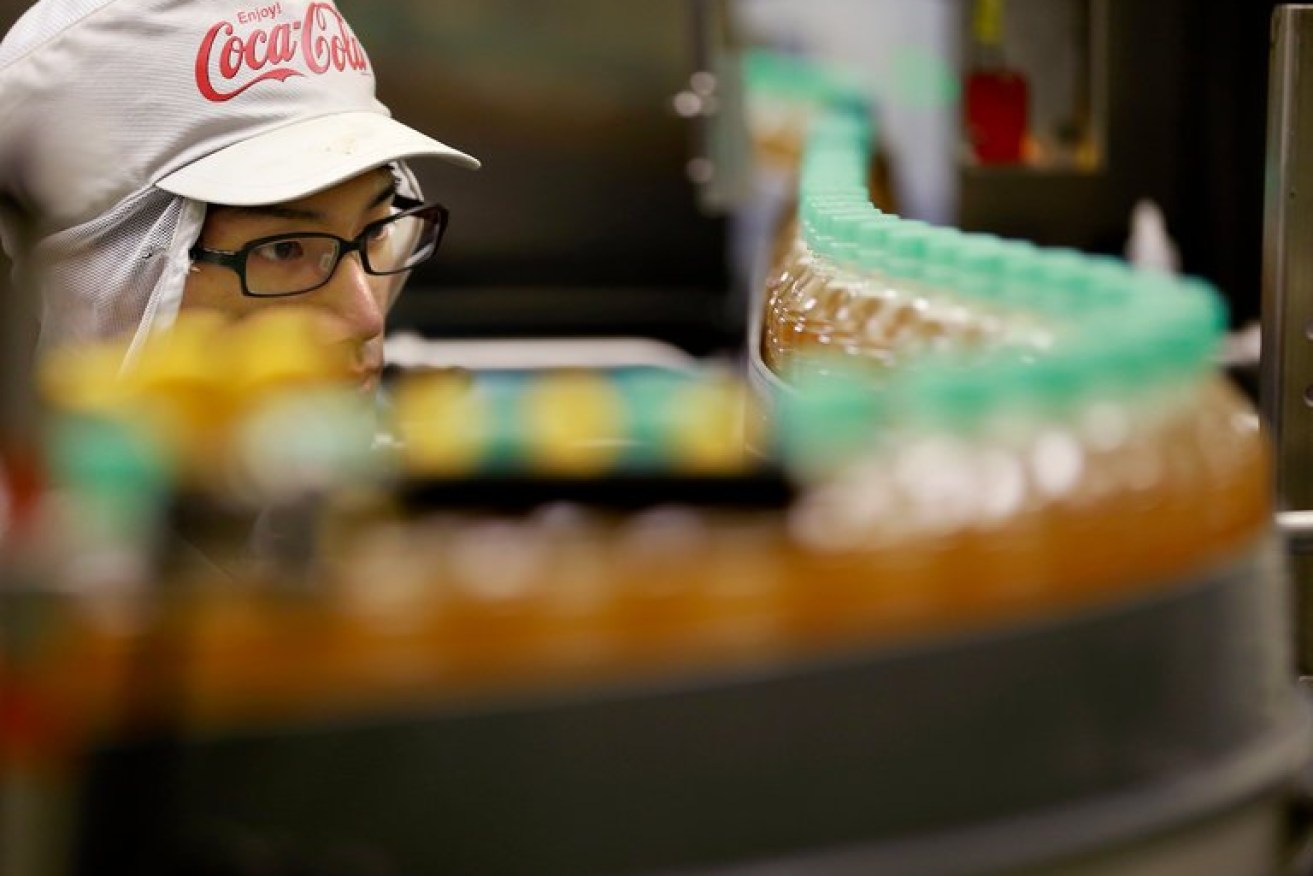 A worker at a Coca-Cola plant near Tokyo. The soft drink giant plans to introduce a fizzy, flavoured drink with alcohol in the Japanese market.