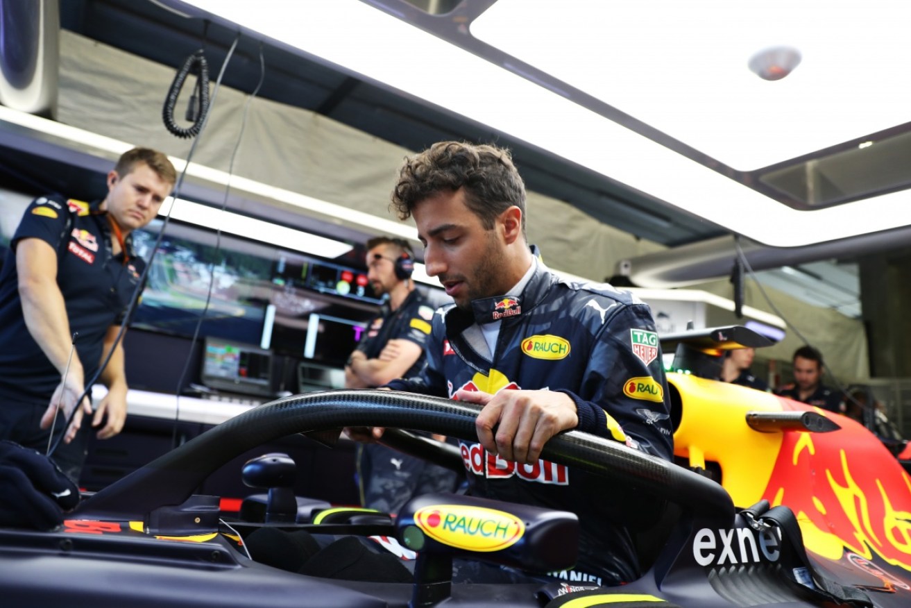 Daniel Ricciardo negotiates the new halo device as he gets into his car. 