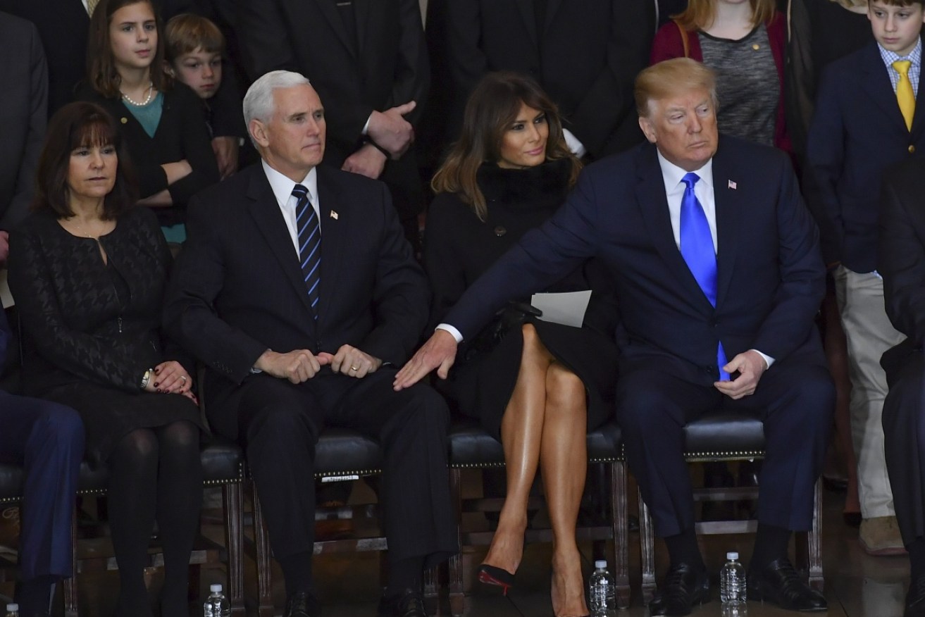 US President Donald Trump (right) provides solace to Vice President Mike Pence (left) while Melania (centre) is left on her own. 