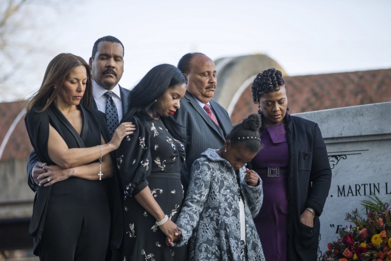 Dexter Scott King, second left, Martin Luther King III, back second right, and Bernice King, right, are joined by their family as they lay a wreath on the grave of their parents' crypt outside of the King Center in Atlanta. 