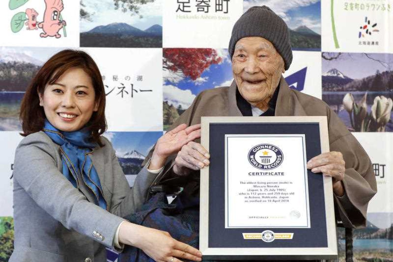 Masazou Nonaka receives the certificate from Guinness World Records as the world's oldest living man at 112 years and 259 days. 
