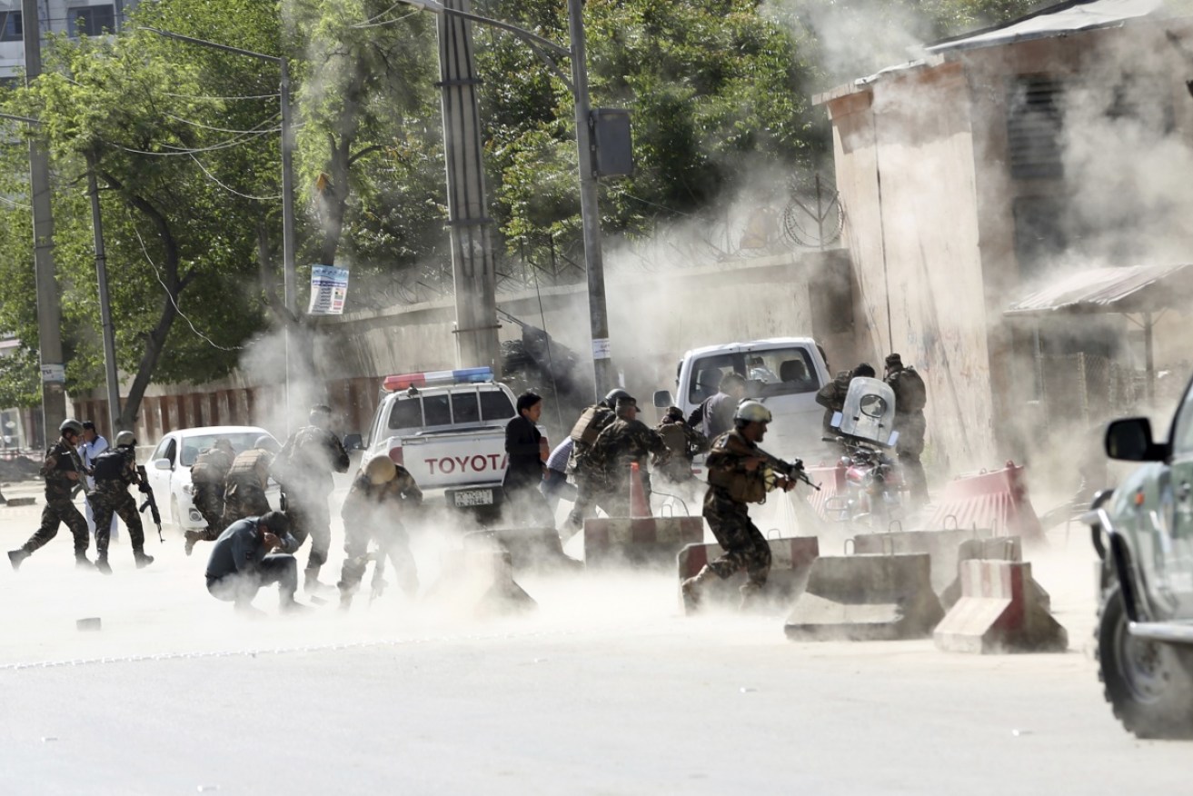 Security forces run from the site of a suicide attack after the second bombing in Kabul, Afghanistan. 