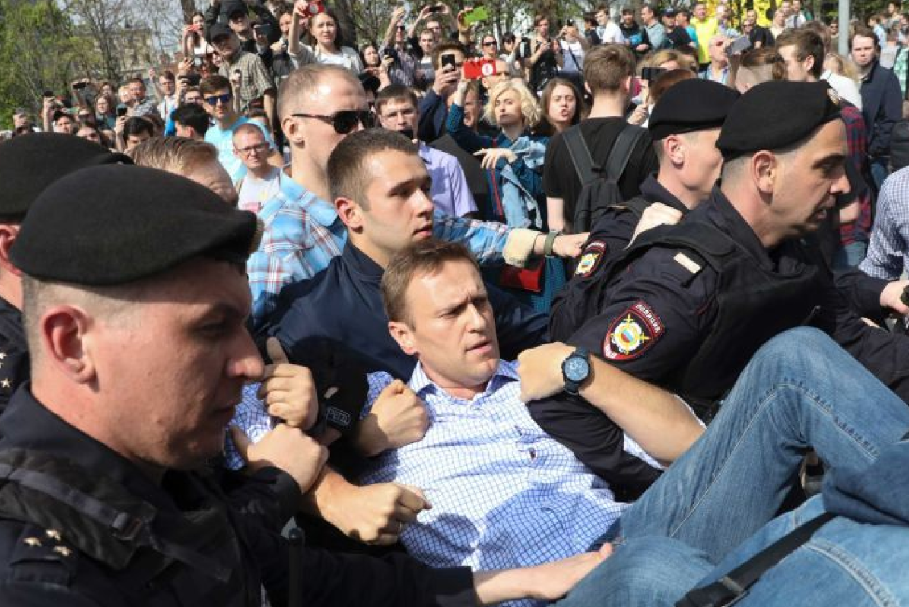 Putin critic Alexei Navalny had only just begun to speak when he was snatched from the stage.