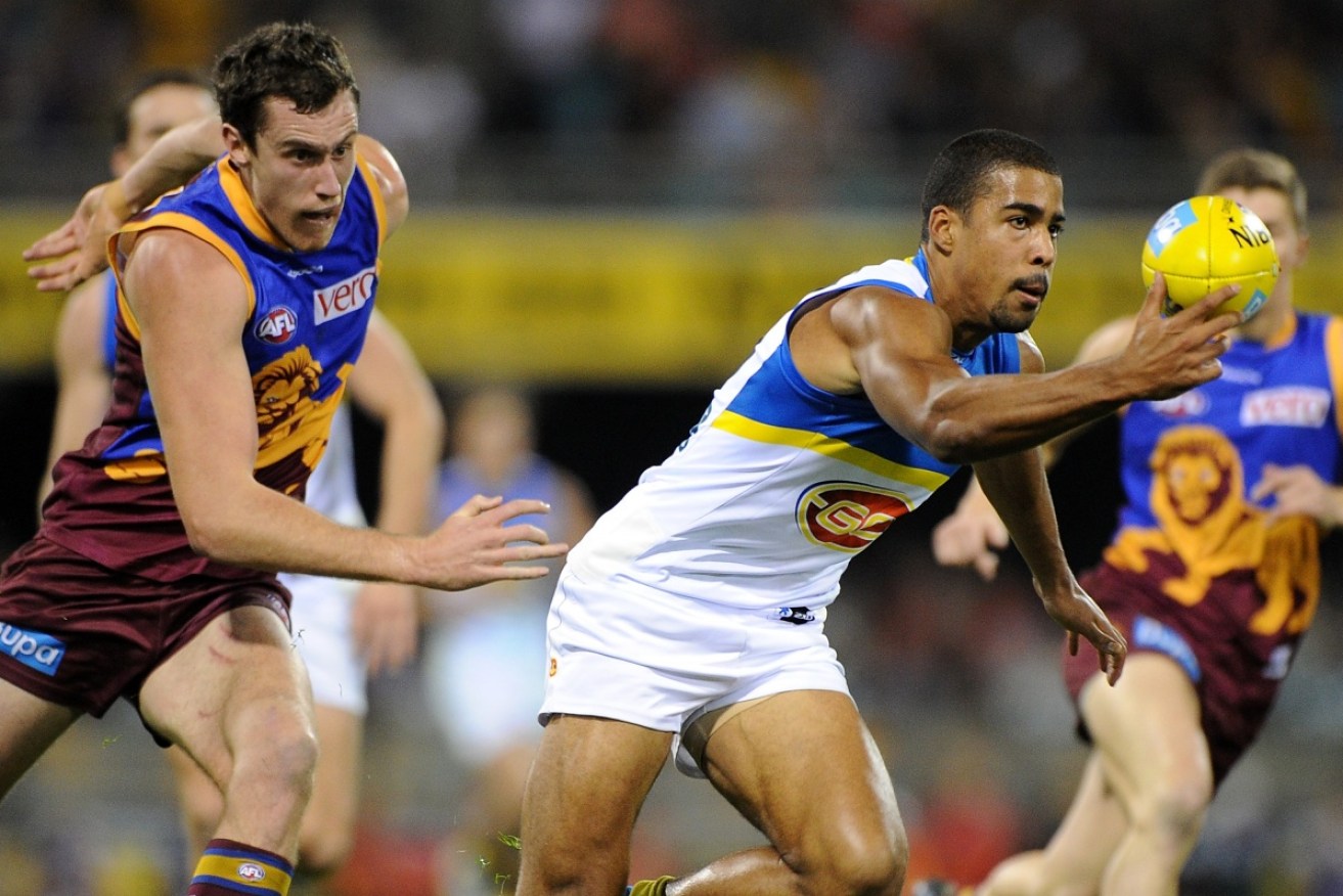 Joel Wilkinson (white jumper) gathers the ball n a match against the Brisbane Lions.