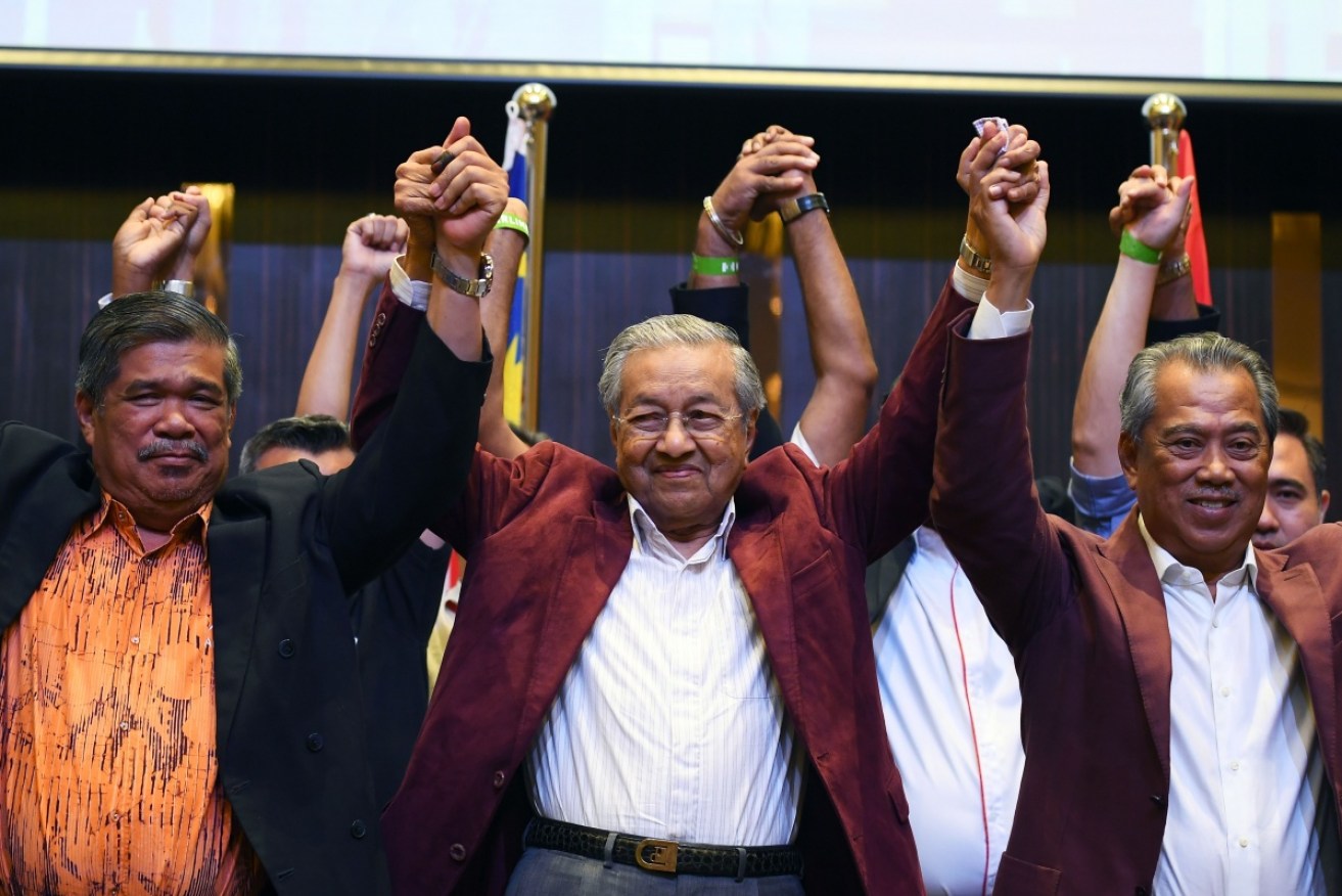 
Former Malaysian prime minister and opposition candidate Mahathir Mohamad (C) celebrates his historic election victory.