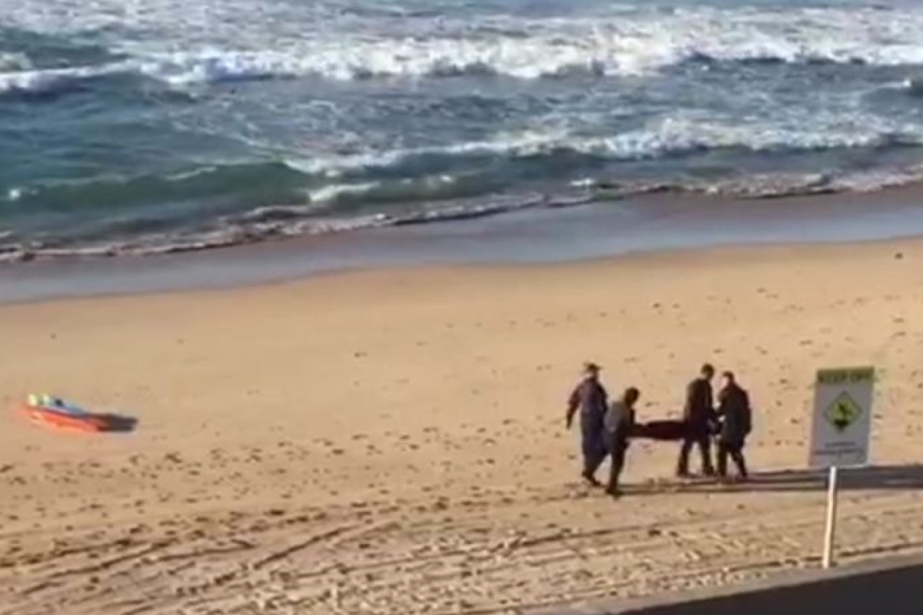 The unidentified woman's body is carried from North Cronulla Beach.
