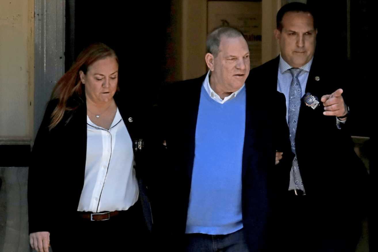 Flanked by two NYPD detectives, disgraced movie mogul Harvey Weinstein surrenders to be charged in Manhattan.