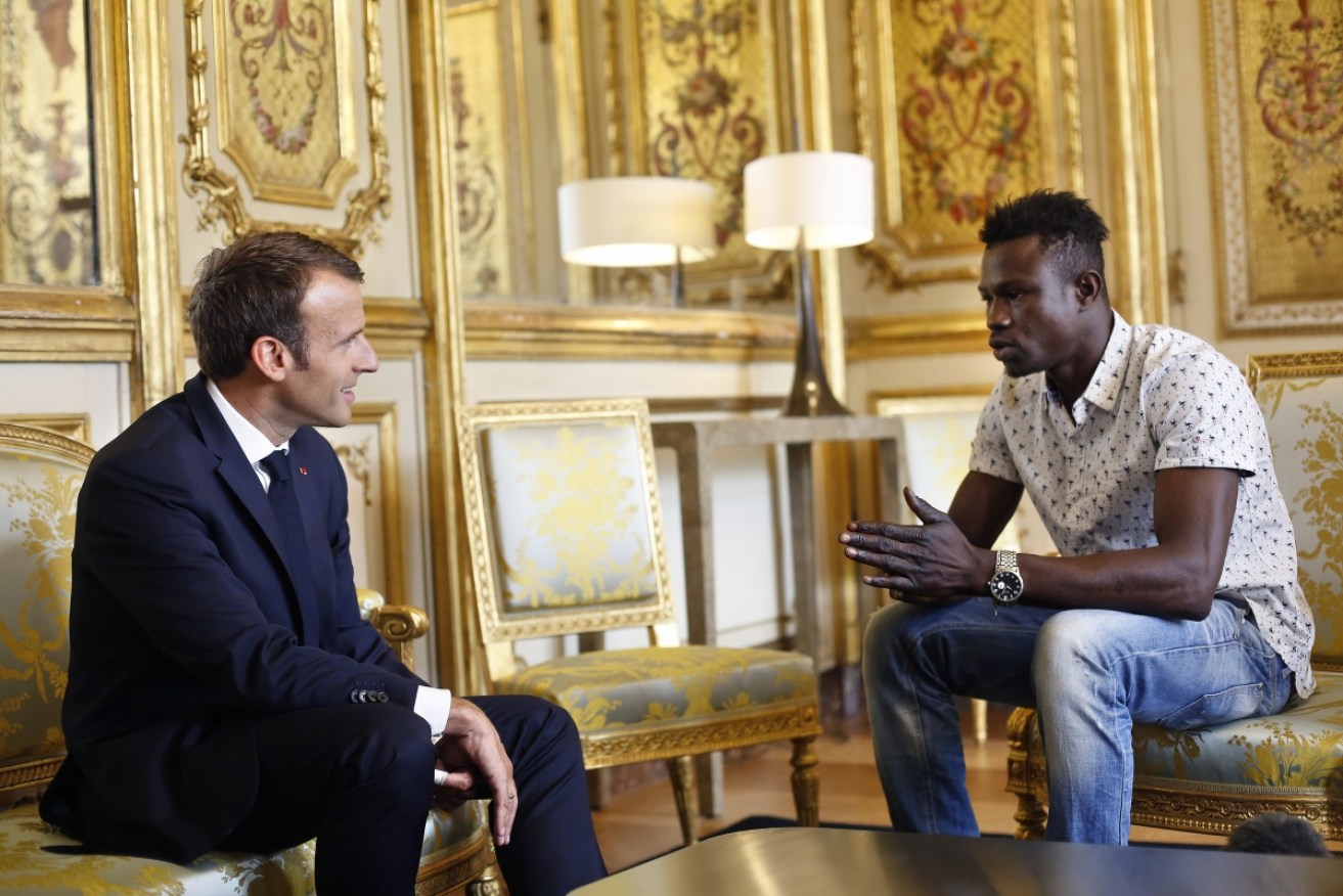 A young Malian migrant who scaled a Paris apartment block to save a child has been rewarded by French President Emmanuel Macron.