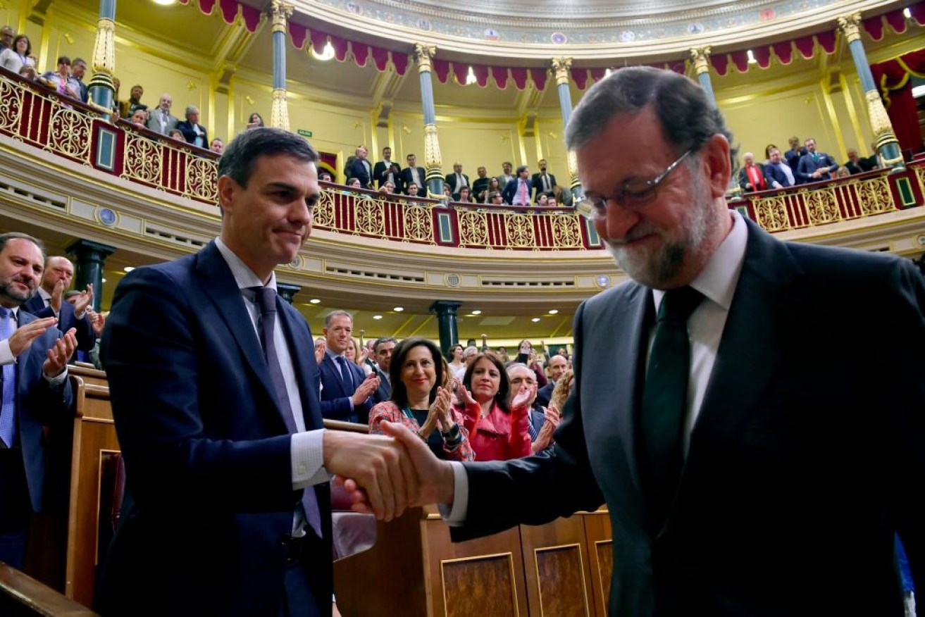 Spain's new PM Pedro Sanchez (L) shakes hands with Spain's out-going Mariano Rajoy (R) after a vote on a no-confidence motion.