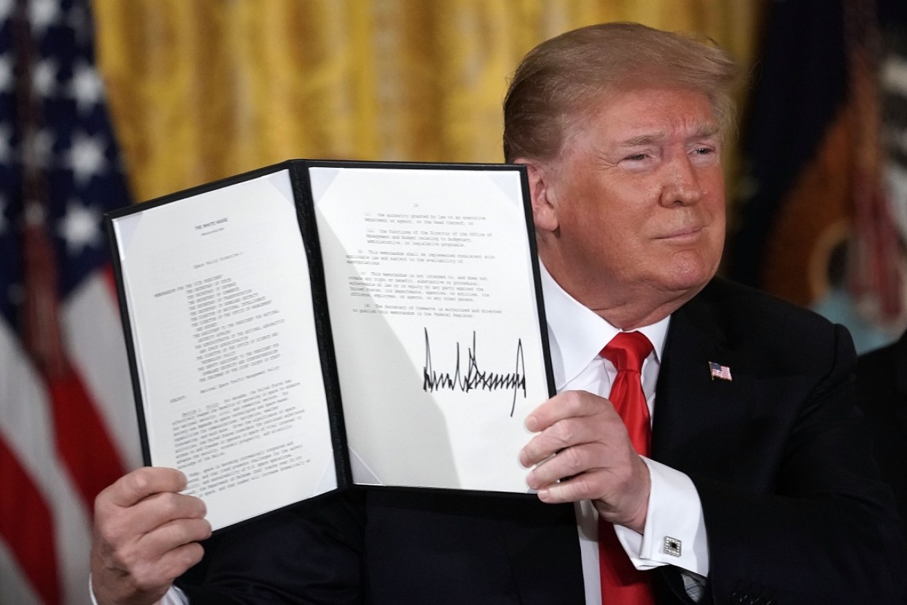 Donald Trump holds up an executive order to establish the Space Force.