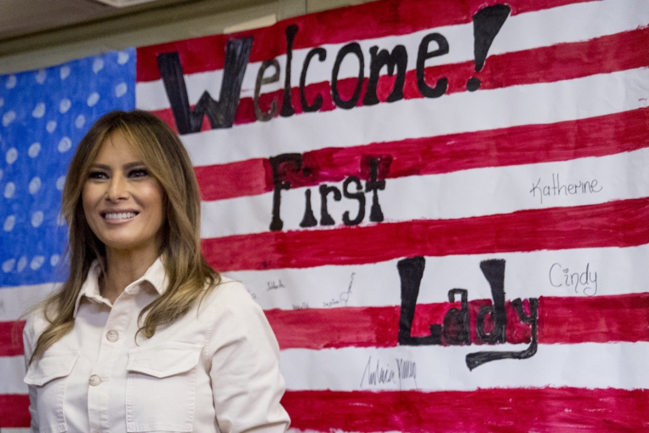 First lady Melania Trump smiles after signing American flag artwork while visiting detained immigrant children.