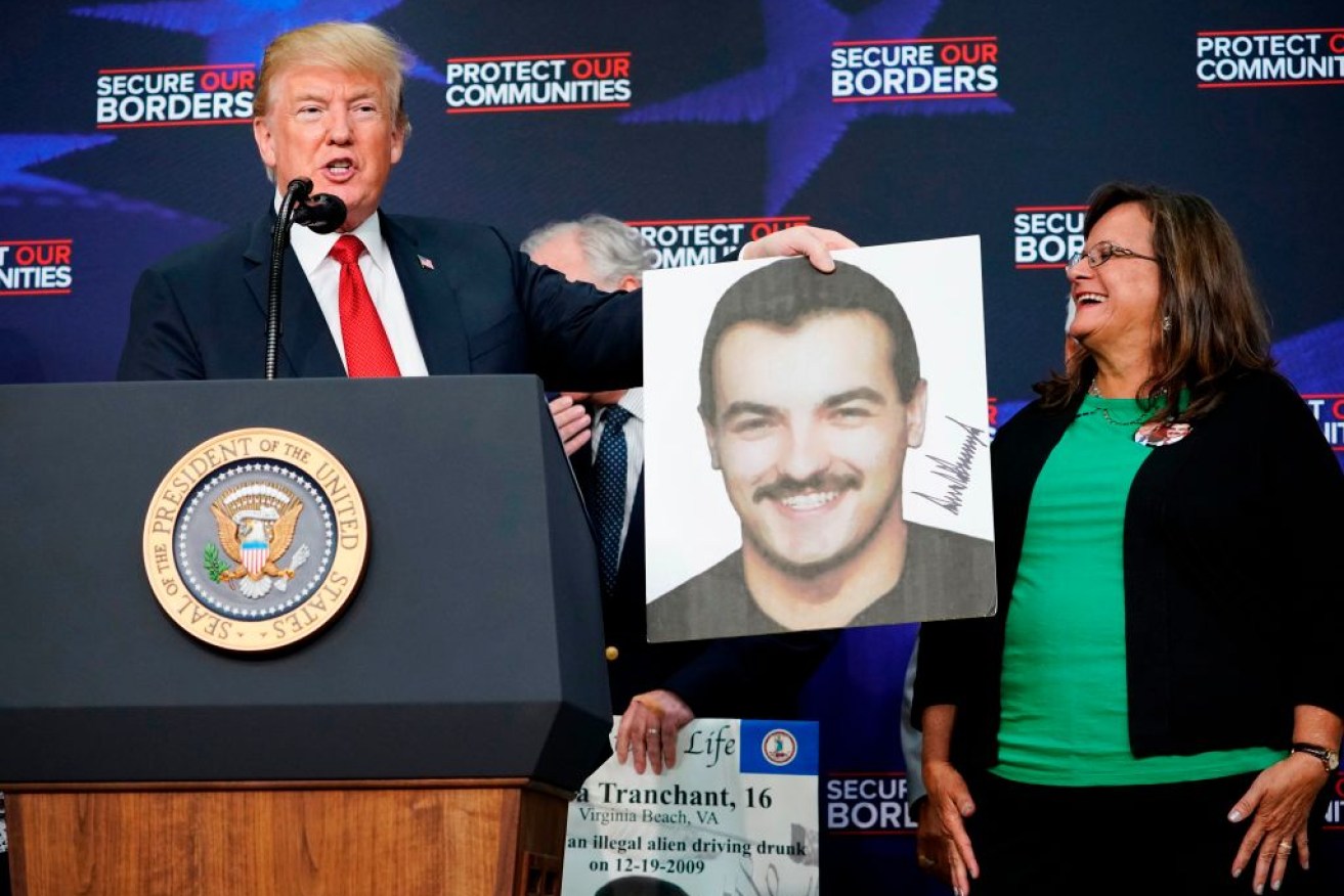 War on illegal immigration: Donald Trump holds a portrait of Ronald da Silva, a victim of a purported undocumented migrant.