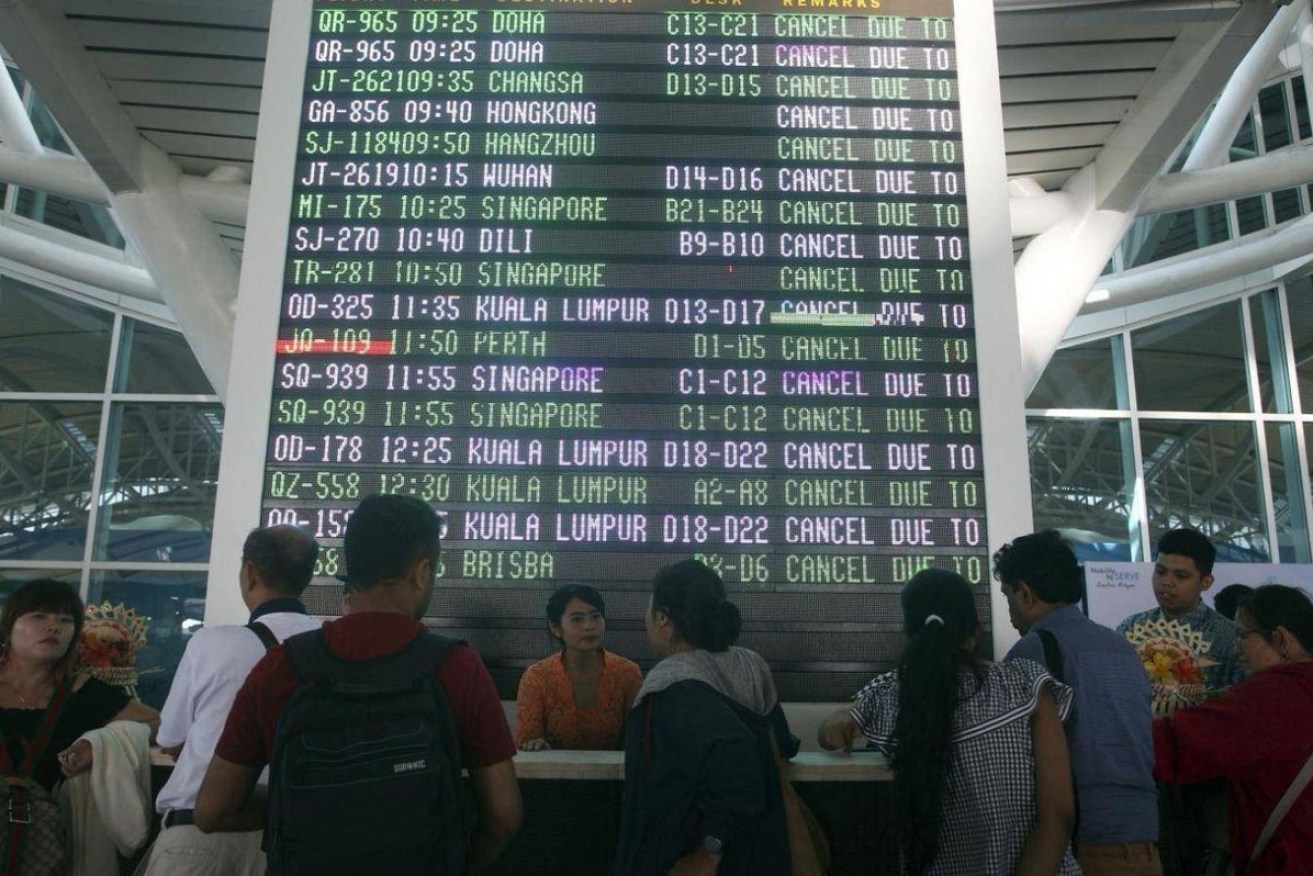 Bali's Ngurah Rai airport has reopened after a 12-hour shutdown but passengers describe 'mayhem' inside the terminal.