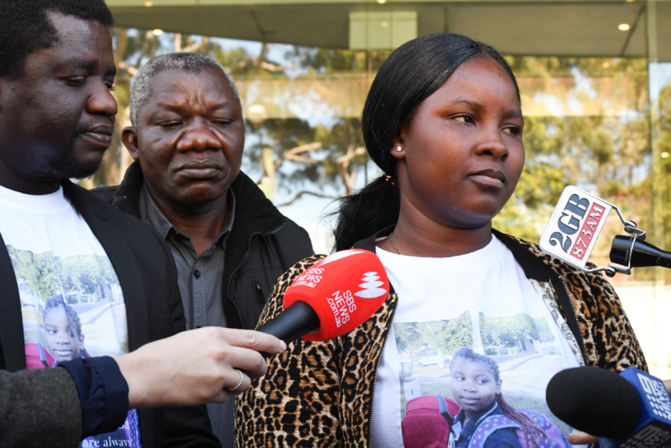 With the image of dead daughter Miata Jibba on her T-shirt, Mary Kpaba speaks with reporters outside the court.