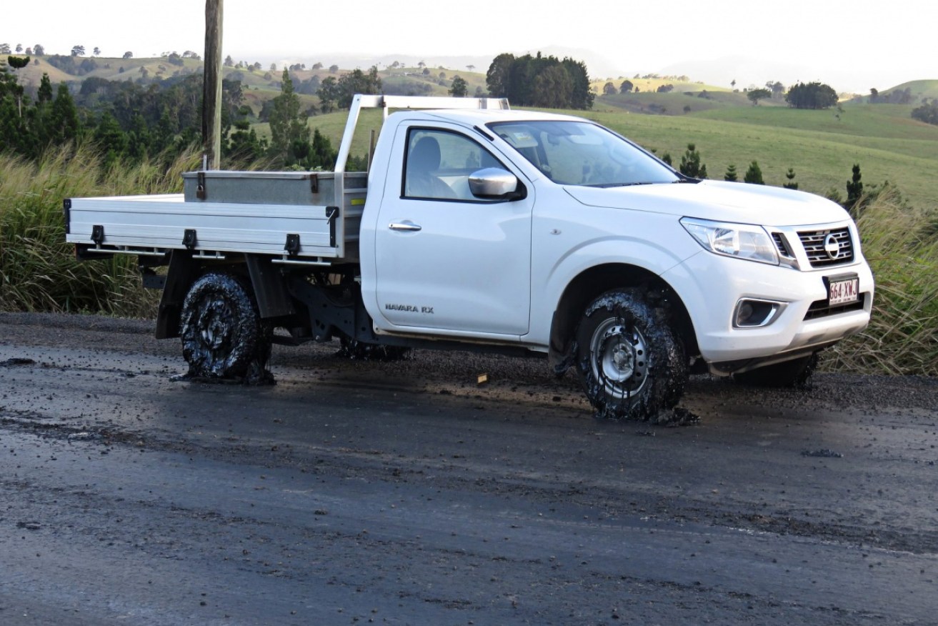 A ute with damaged tyres is pictured after bitumen lifted on the Millaa Millaa-Malanda Road.