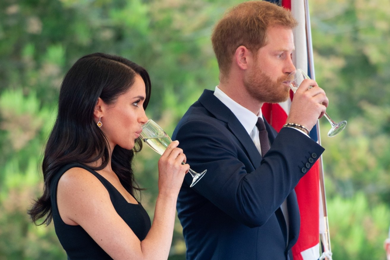 Bottoms up: Prince Harry and wife Meghan Markle sip champagne at a garden party in Ireland.