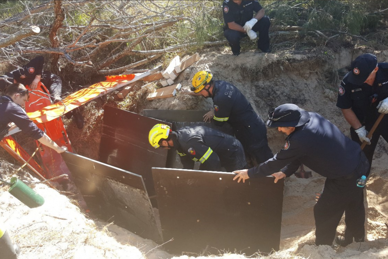 A man in his 20s was rescued after being buried in sand up to his neck.