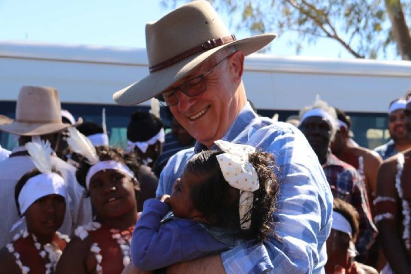 Malcolm Turnbull embraces a child in Tennant Creek. 