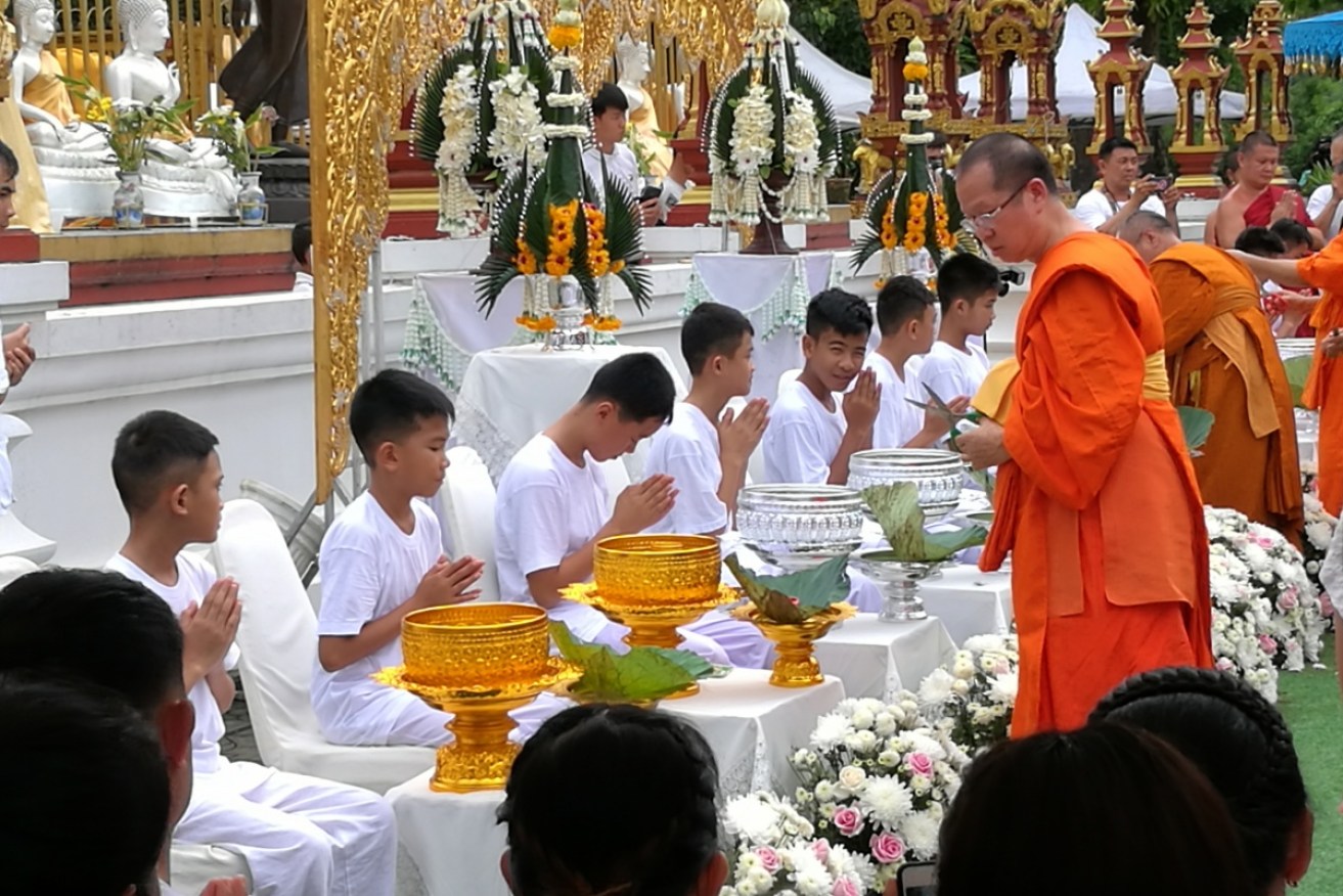 Members of the Wild Boars soccer team   receive hair cuts by   Thai Buddhist monks.  