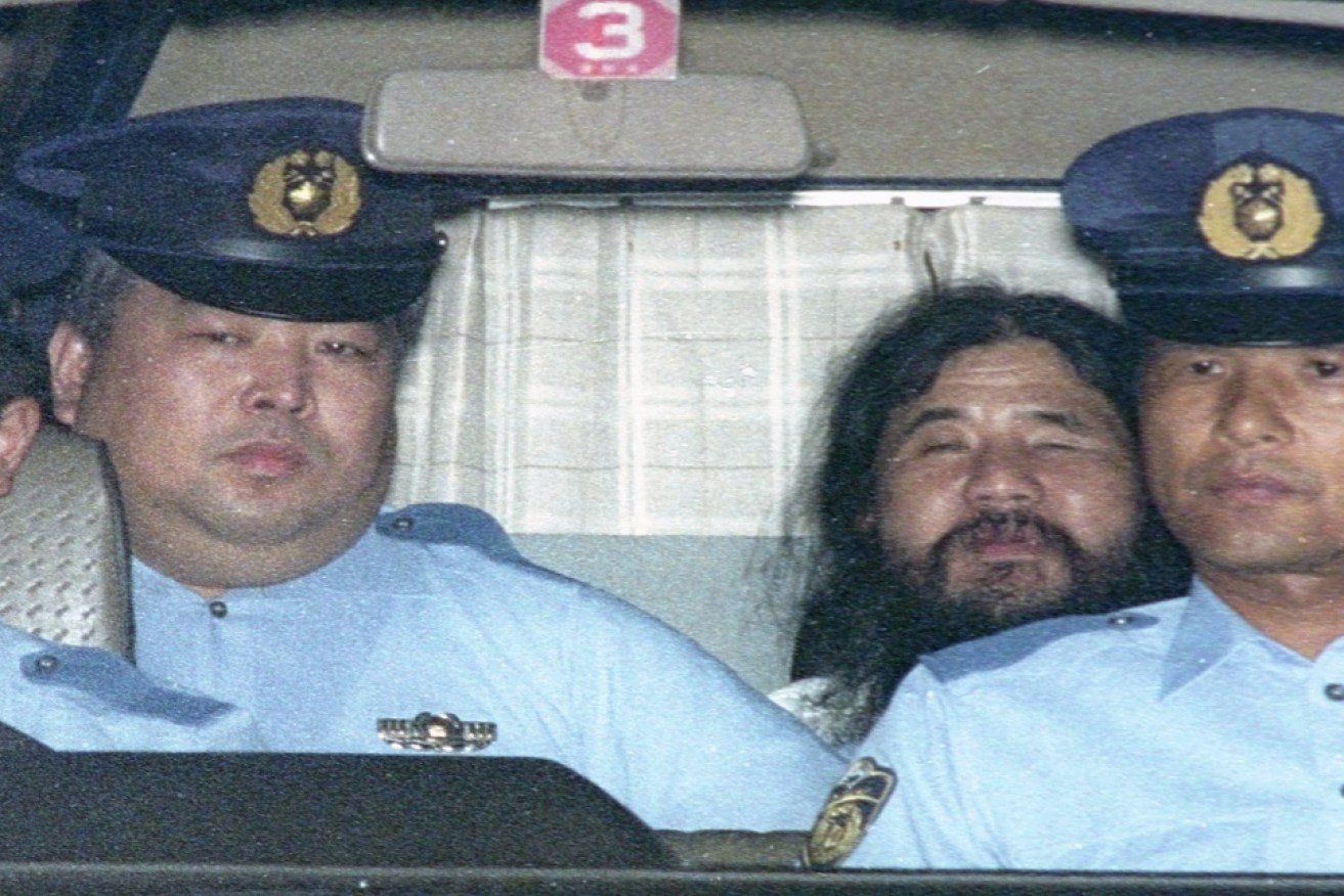Shoko Asahara returns from court to jail during his 1995 trial. 