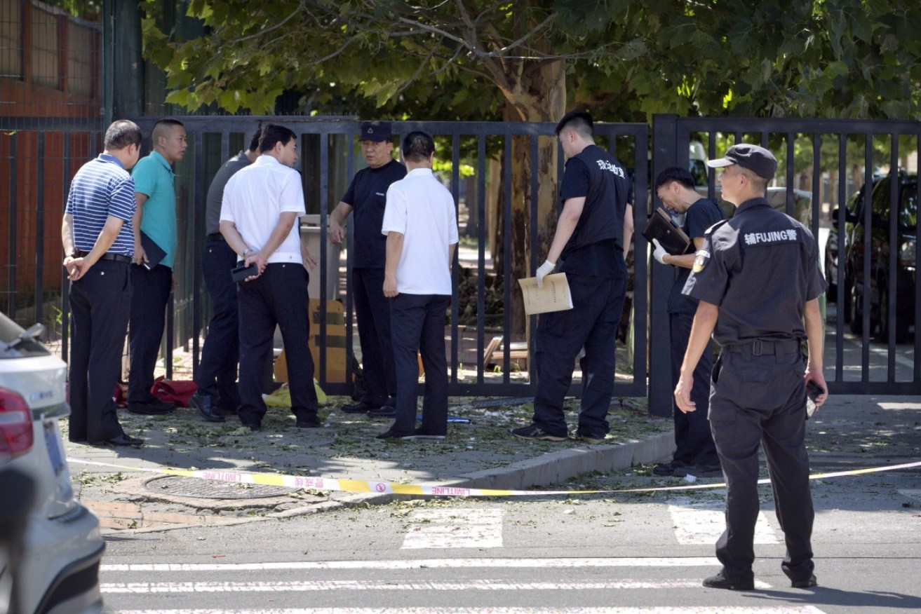Officials stand near the site of reported blast just south of the US Embassy  on Thursday. 