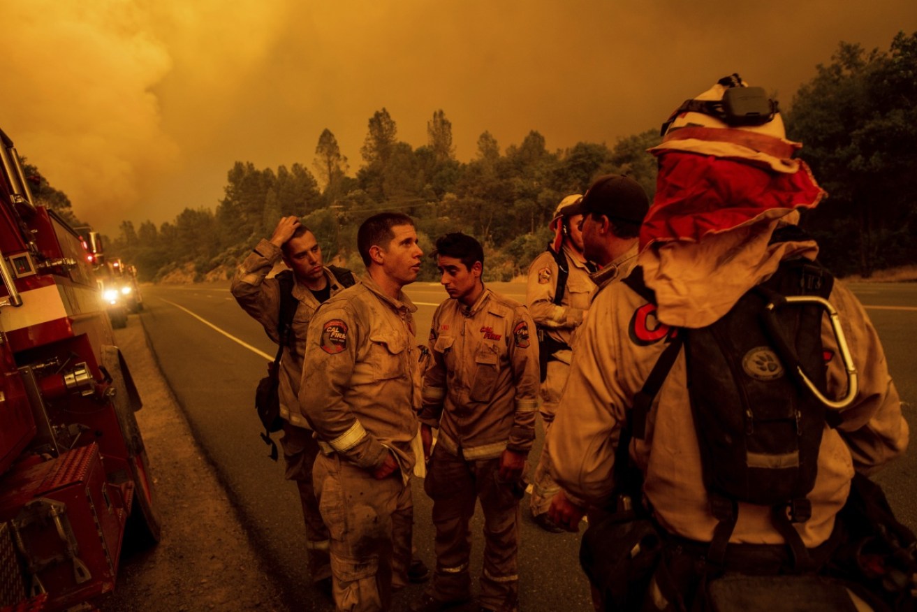 Fire officers earlier in the bushfire season at the Carr fire as it blazed its way into Redding in northern California.