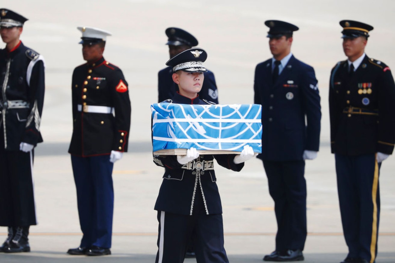 A soldier at Osan Air Base carries a casket containing the remains of a US soldier killed during the Korean War.