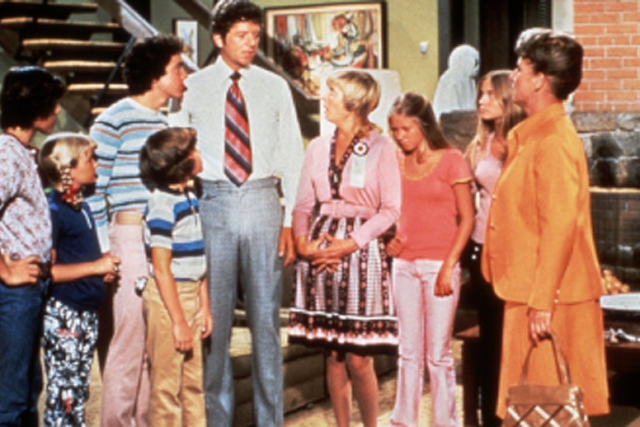 The fictional Brady family (and faithful housekeeper Alice) hang out in their 1970s living room. 