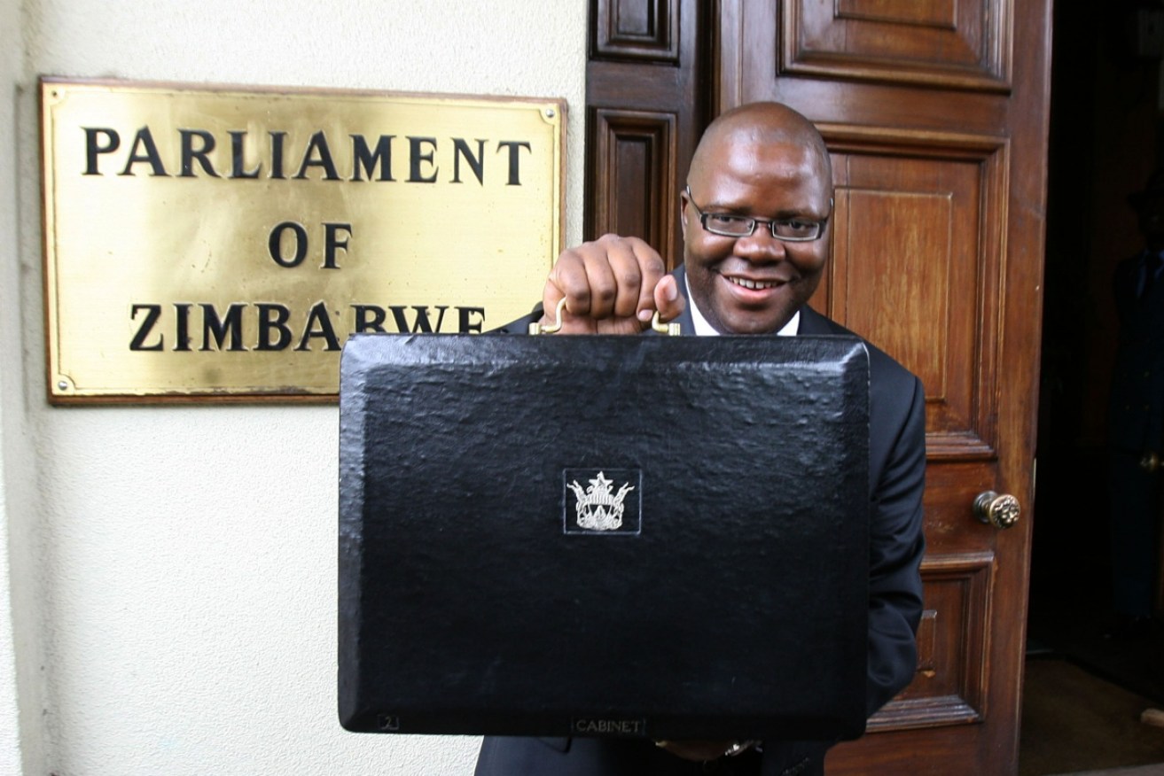 In happier days, then Zimbabwean Finance Minister Tendai Biti poses with the 2010 budget papers in Harare.
