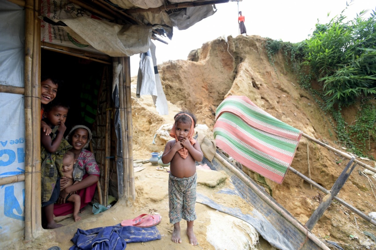 Shehena, 2, stands in front of the Begum family home. They smile despite loosing their previous bamboo and tarpaulin hut in a landslide.