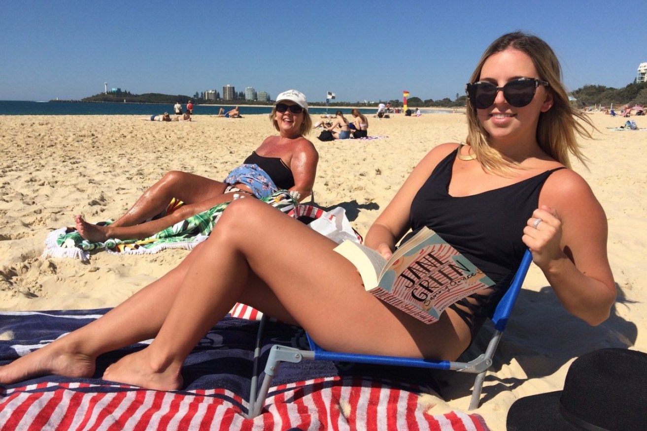 Victorian tourists Lucy and Narelle O’Connor enjoy Queensland’s winter sunshine on Mooloolaba Beach. 