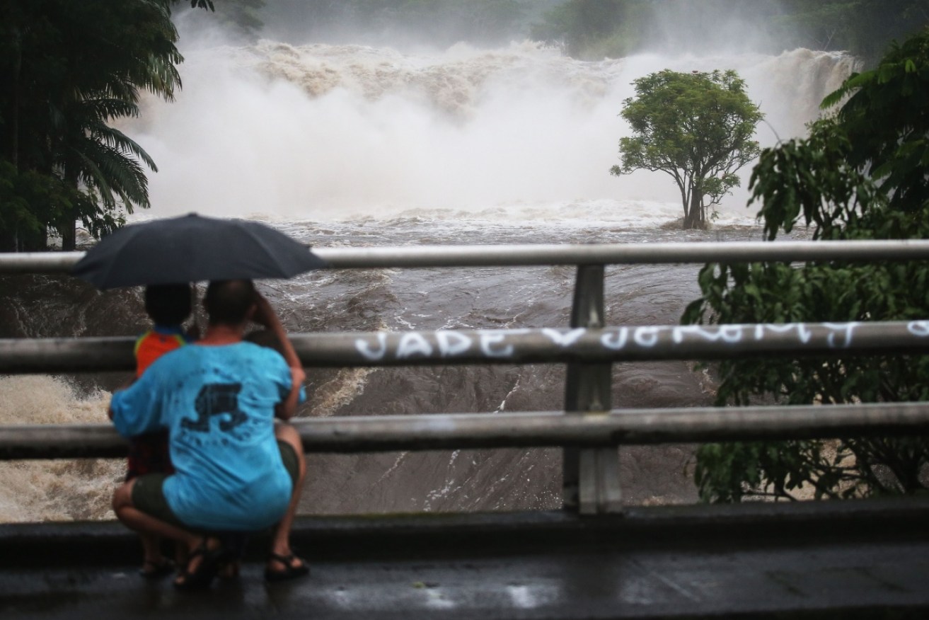 People watch the Wailuku River floods on the Big Island on August 23, 2018 in Hilo, Hawaii.