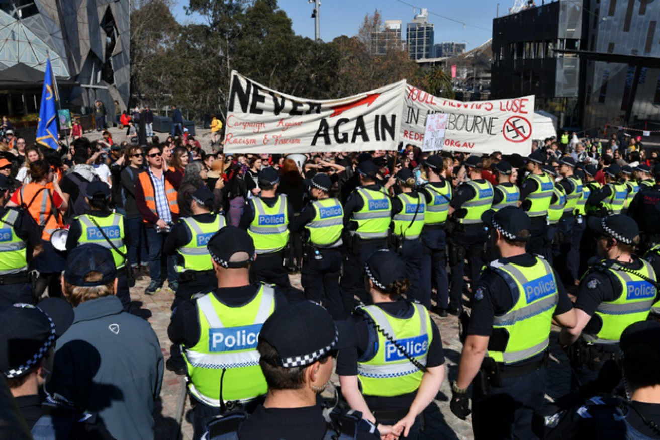 Lines of police form a human barrier to keep the rival protesters apart in Melbourne's Federation Square.