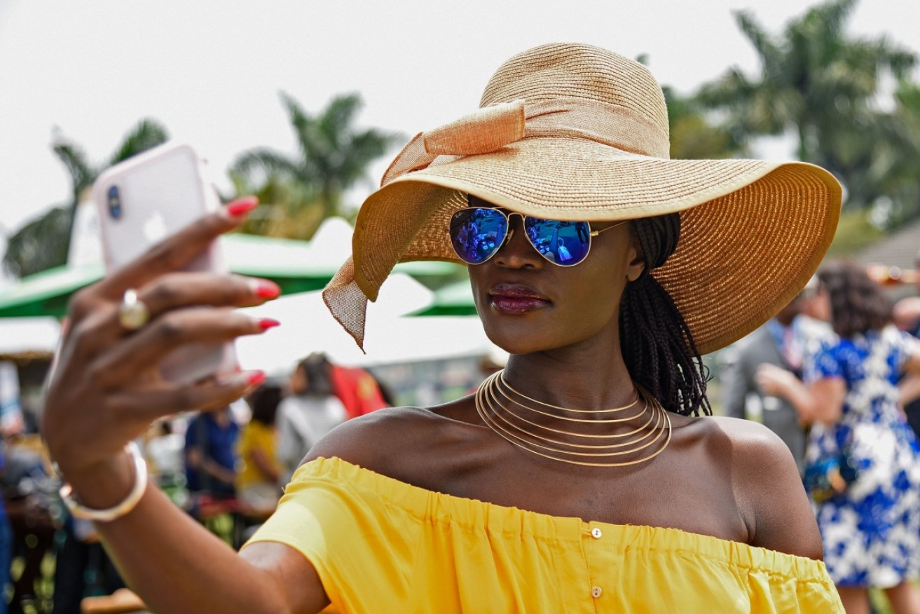 A woman takes a selfie at the Royal Ascot Goat Races in Kampala, Uganda. 