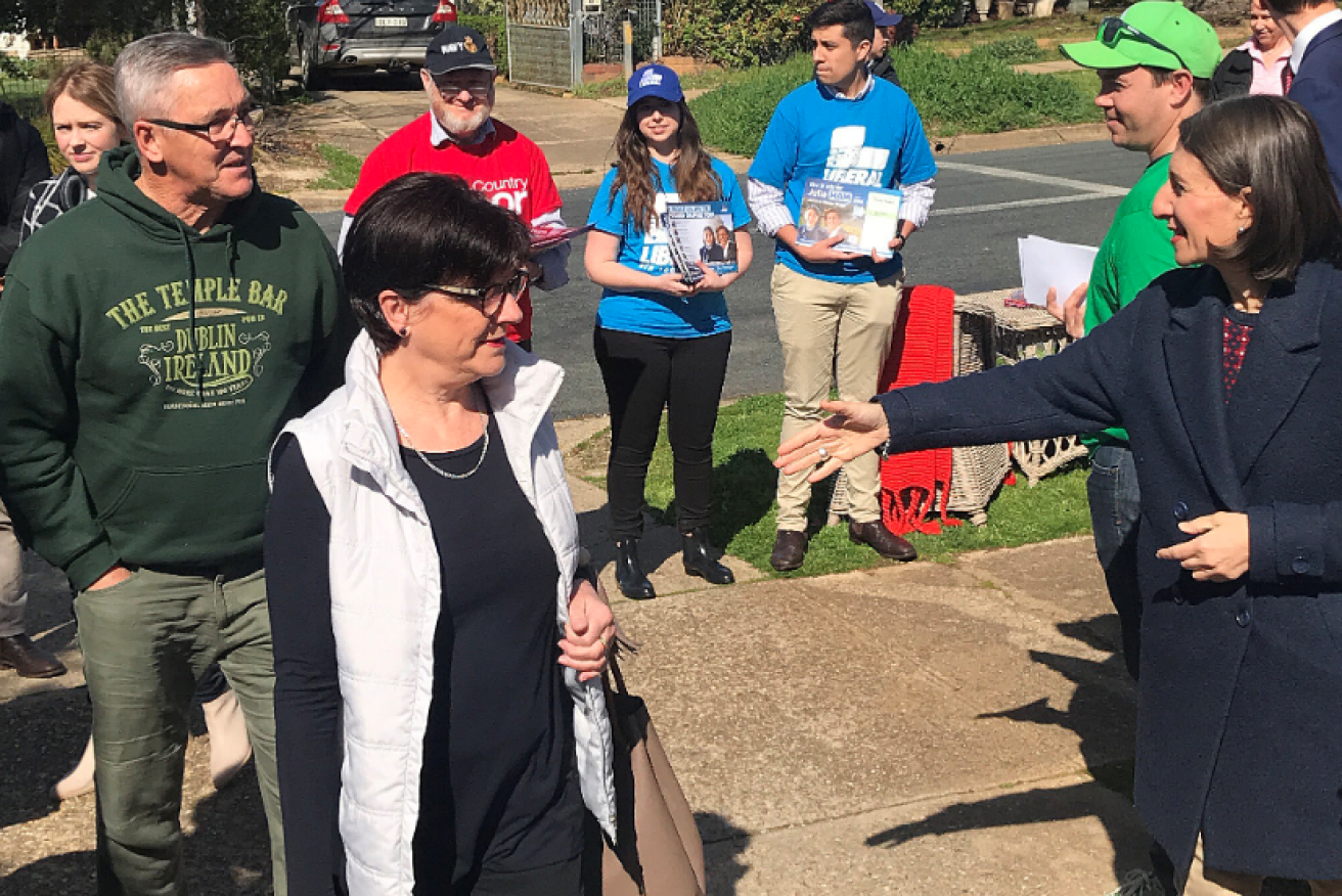 NSW Premier Gladys Berejiklian (left) welcomes voters to a polling station, but the affection wasn't reciprocated.