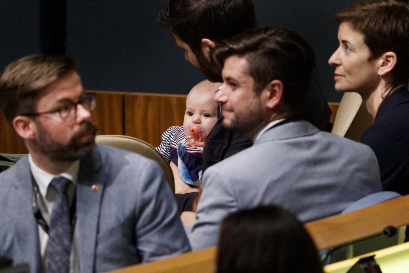 Clarke Gayford and baby Neve listen while Jacinda Ardern speaks the UN general assembly.