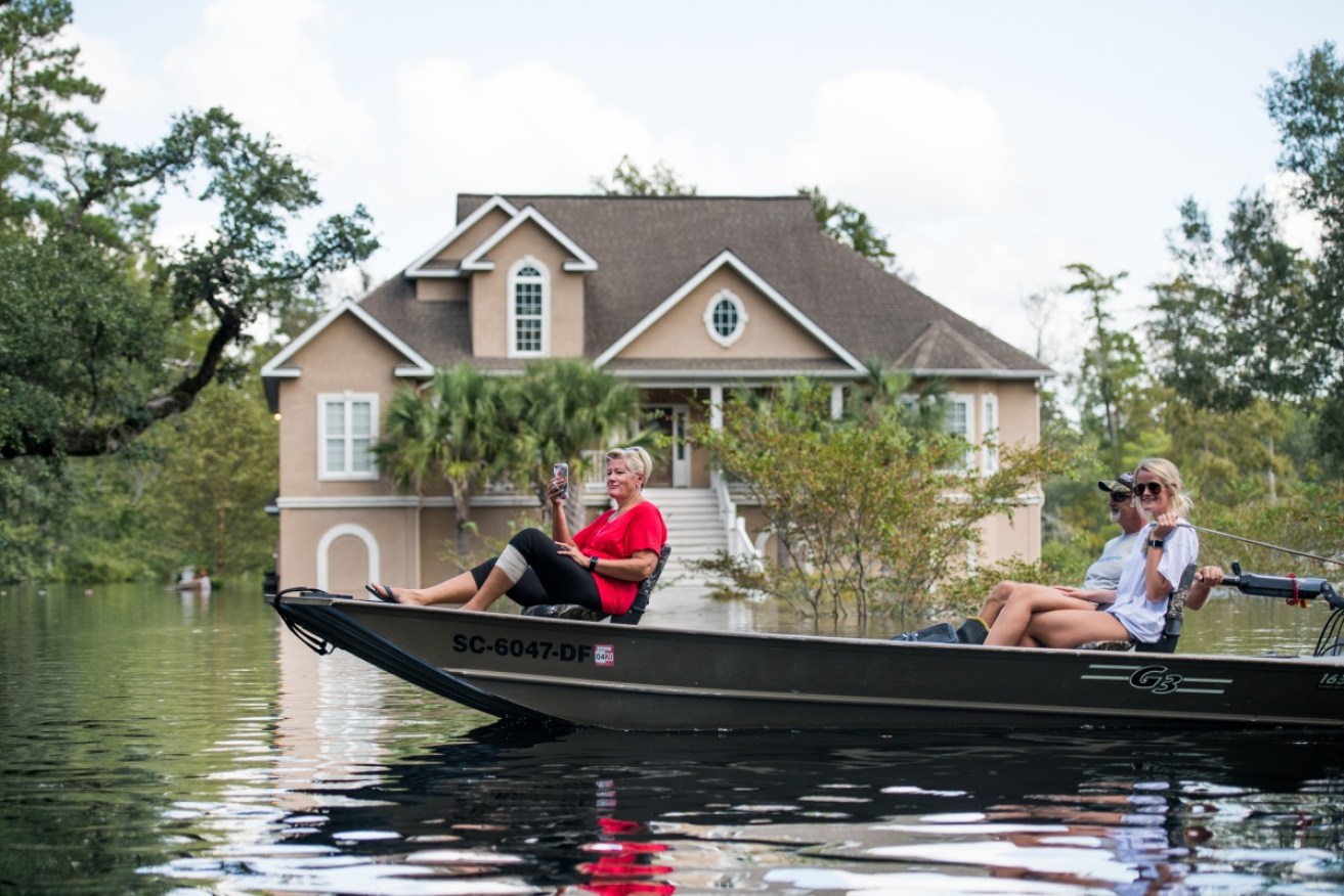 People navigate floodwaters near the Waccamaw River in Conway, South Carolina.