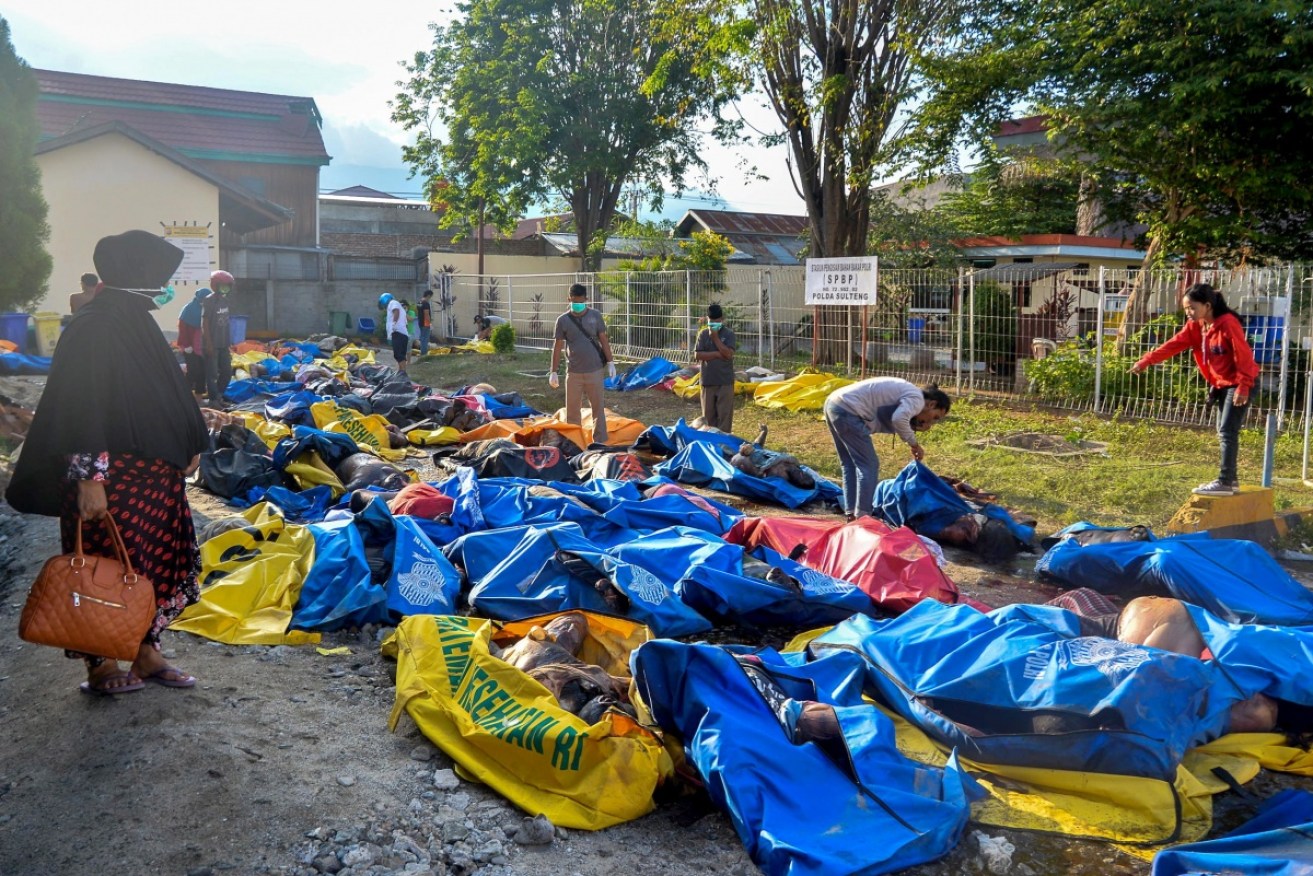 Survivors search body bags for loved ones lost to the earthquake and tsunami in Palu.