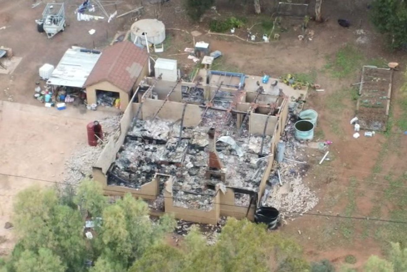 A house was burnt down after armed men allegedly stormed the property and assaulted a man.