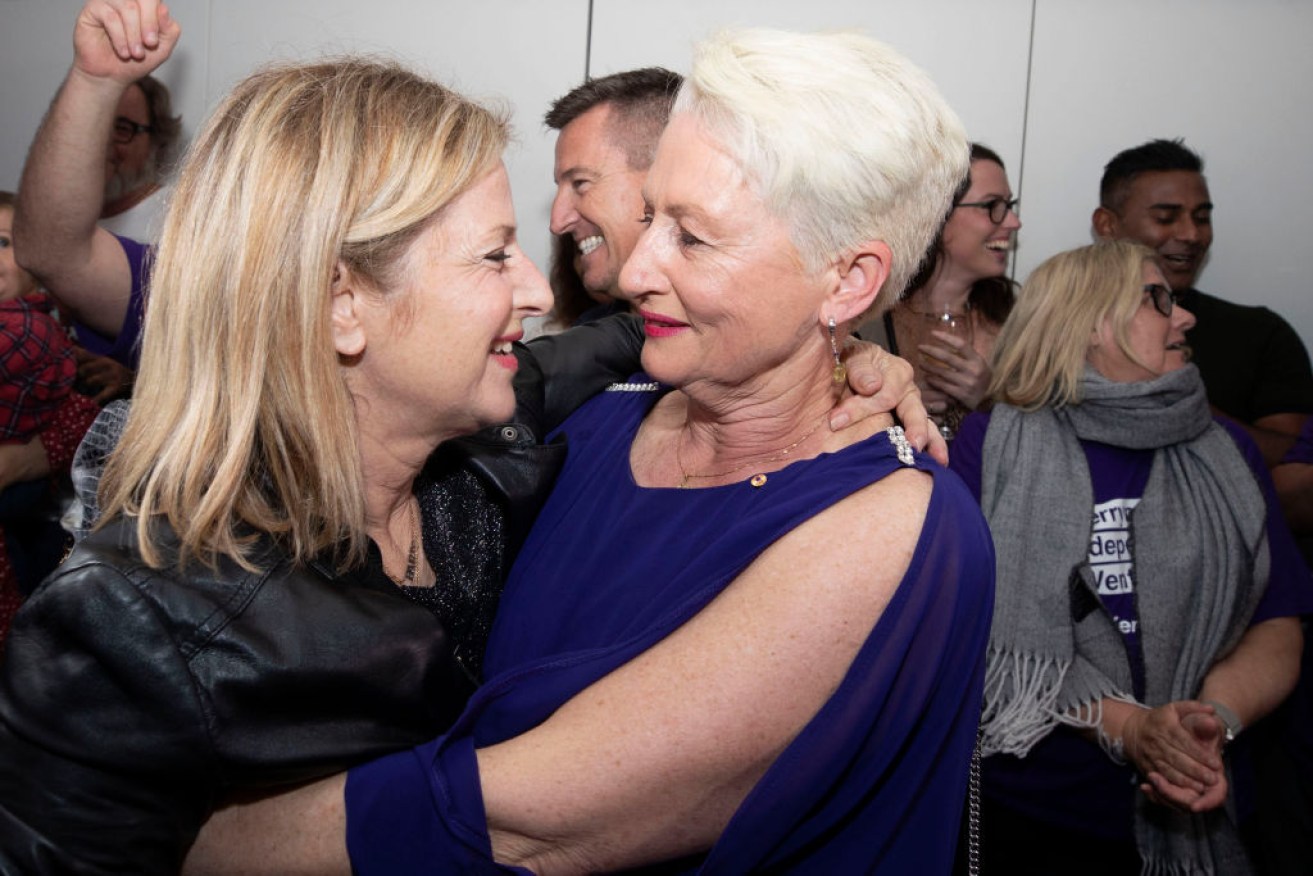 The new Member for Wentworth, Dr Kerryn Phelps, embraces her wife Jackie Stricker-Phelps.