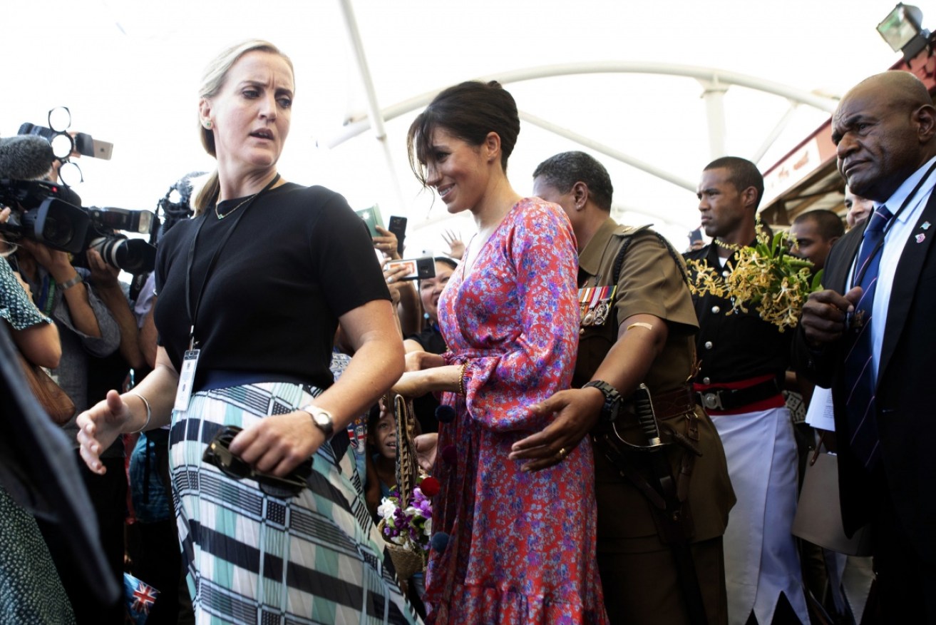 The Duchess of Sussex is escorted through a market in Suva, Fiji, on Wednesday. 