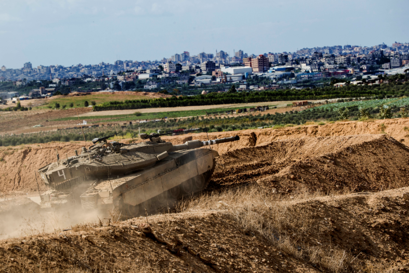 An Israeli tank takes up its position on high ground overlooking Gaza as the airstrikes continue.