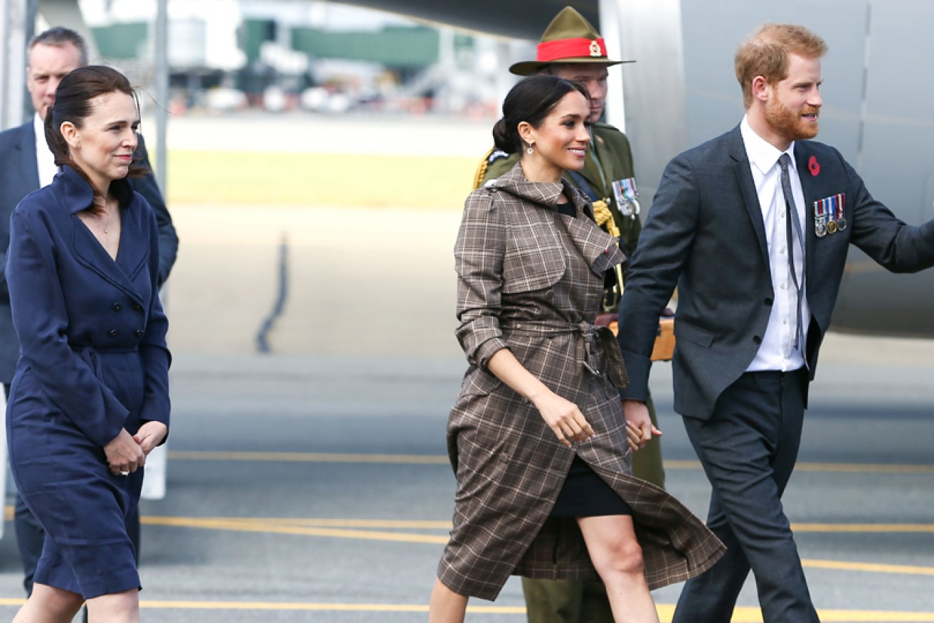 New Zealand PM Jacinda Ardern greets the Duke and Duchess of Sussex on the tarmac in Wellington.