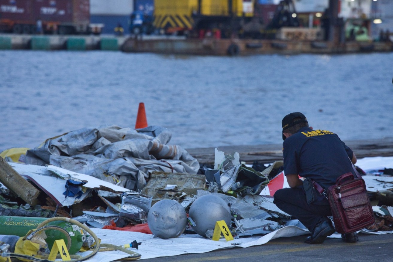 A forensic investigator looks through the remains of the ill-fated Lion Air flight at the Tanjung Priok port. 